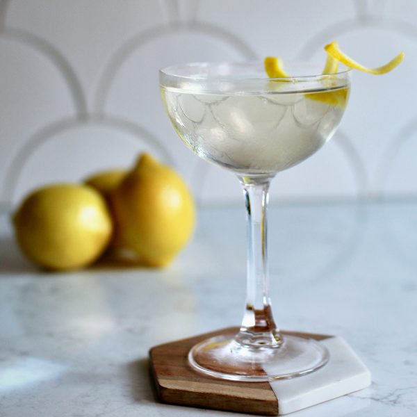 Scalloped white tile behind a lemony looking martini