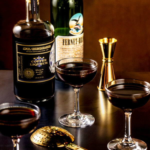 A NOLA bottle, a bottle of Fernet Branca and some cocktail making equipment