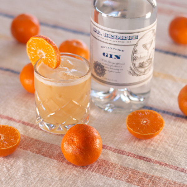 mandarins piled around a tumbler of drink